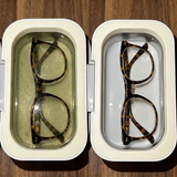 The same glasses before and after Lensio, filthy grey water beside clear water
